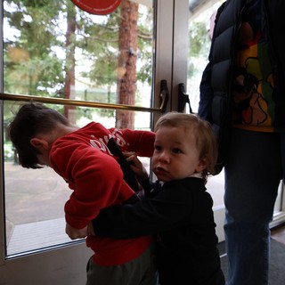 Two Young Children Playing by Glass Door