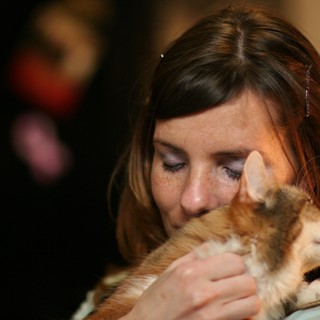 Tender Moment: Woman Nuzzles Beloved Kitten Closely