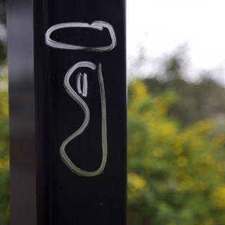 Engraved Metallic Post Against Blurred Natural Background