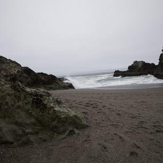Wild Cove Beach Framed by Dark Sea Cliffs