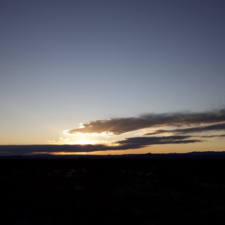 Dramatic Desert Sunset Over Distant Mountain Range