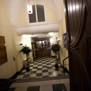 Grand Entrance Hall with Checkered Floor and Wooden Staircase