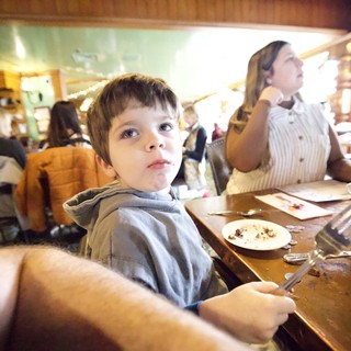 Young Boy at Family Restaurant Dining Table