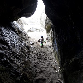 Young Explorer Ventures Into Rocky Coastal Cave