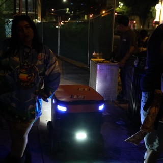 Delivery Robot Navigates Nighttime Festival Crowd