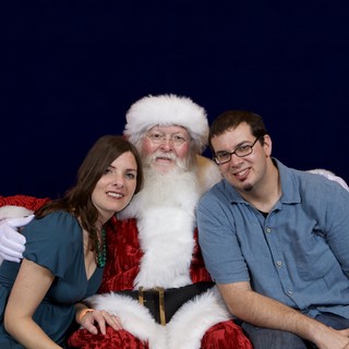 Couple Poses with Santa at Christmas Party