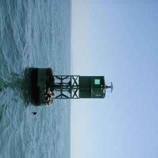 Green Light House in the Middle of the Ocean