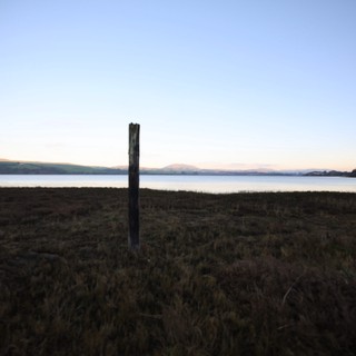 Solitary Wooden Post at Twilight Coastal Shore