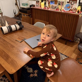 Toddler in Santa Pajamas at Home Workspace