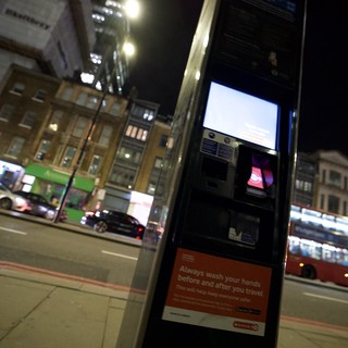 Night Scene at London Bus Stop with Health Advisory