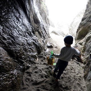 Young Explorer Ventures Through Sea Cave Passage