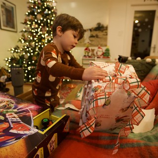 Child Unwrapping Christmas Presents on Christmas Morning