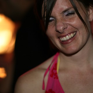 Laughing Woman in Pink at a Nighttime Gathering