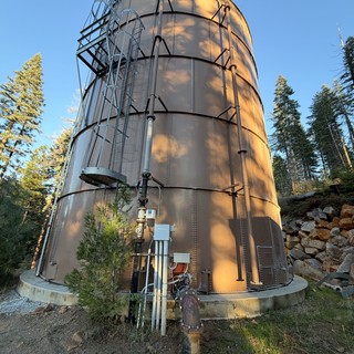 Industrial Steel Water Tank in Mountain Forest Setting