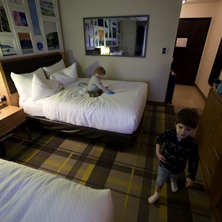 Two Young Children Playing in Modern Hotel Room