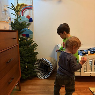 Two Young Children Exploring Their Christmas-Decorated Bedroom