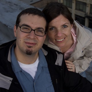 Dave and Penelope Smiling Atop Urban Rooftop
