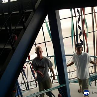 Two men posing on a staircase inside a building in Ensenada