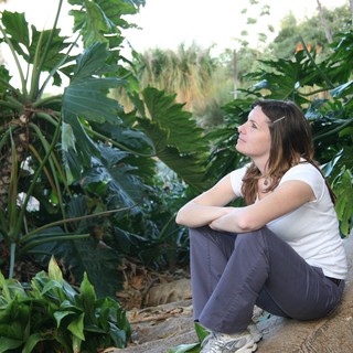 Contemplative Woman Resting Among Tropical Foliage