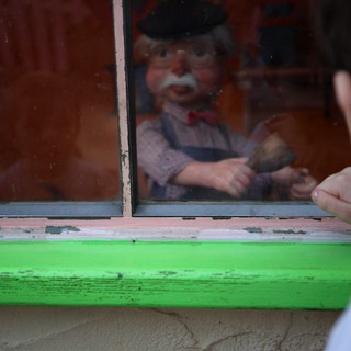 Vintage Puppet Display Behind Weathered Green Window