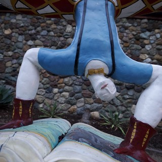 Headless Figure Installation at Stone Wall Backdrop