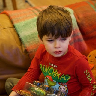 Young Boy Reading Christmas Book on Cozy Couch