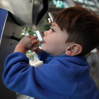 Young Boy Exploring Interactive Exhibit at Science Center