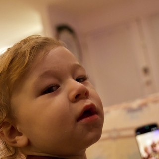 Curious Toddler Looking Up During Christmas Celebration