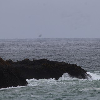 Rough Seas Breaking Against Dark Coastal Rocks