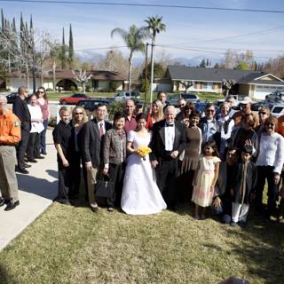 Wedding Party Stands Together in Front of Beautiful Home