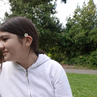 Young Woman with Daisy in Park Setting