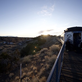 Sunset Train Journey Through Desert Landscape