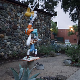 Whimsical Acrobatic Sculpture in Garden Setting at Dusk