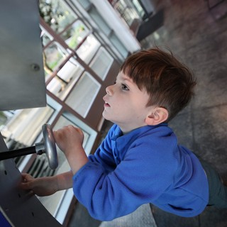 Young Boy Exploring Spiral Staircase at Science Center