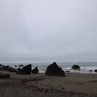Moody Overcast Shoreline with Dark Sea Boulders
