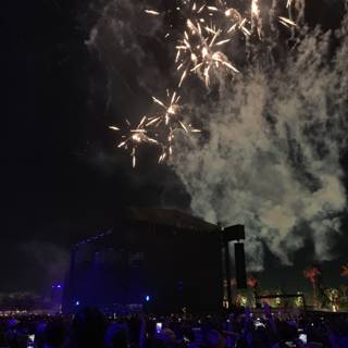 Fireworks Illuminate the Night Sky over a Concert Crowd
