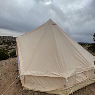 Mountain Tent under a Cloudy Sky