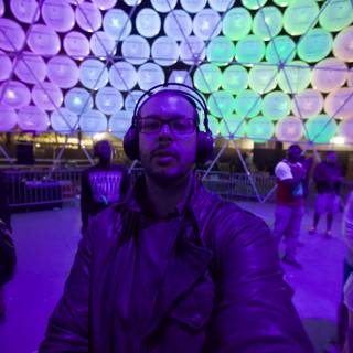 Electrifying Nightlife at Coachella: Man Listening to Music in Front of Large Dome
