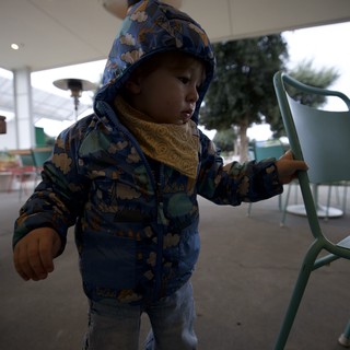 Toddler in Patterned Blue Jacket at Covered Patio