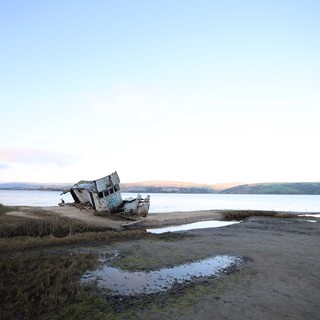 Abandoned Shipwreck at Twilight on Coastal Mudflats