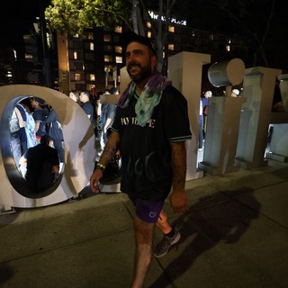 Festival Goer Poses at Wobbleland Sign at Night