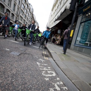 Bike Share Cyclists Riding Through London Shopping Street