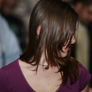 Hair Cascading Over Face at Indoor Gathering