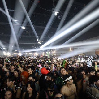Massive Indoor Rave Crowd Under Dramatic Light Beams