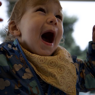 Joyful Toddler Laughing with Excitement at Mealtime