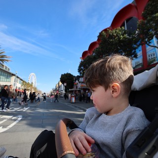 Young Boy Enjoying a Stroller Ride in Chinatown