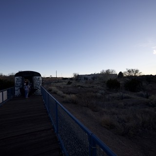 Twilight Crossing: Blue Bridge and Desert Landscape at Dusk