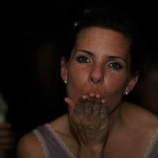 Woman Blowing a Kiss at Evening Celebration