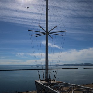 Silhouetted Ship Mast Against Coastal Skyline
