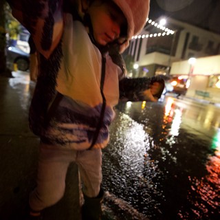 Child Explores Ice Installation at Nighttime Downtown Event